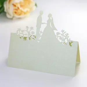Detail view of laser-cut wedding table card featuring bride and groom silhouette