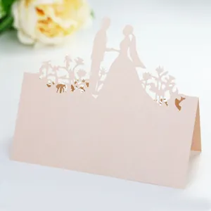 Detail of laser-cut wedding place card with couple silhouette on pearl paper