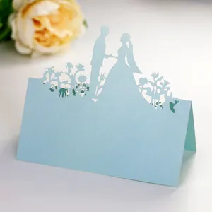 Macro shot of light blue laser-cut wedding table card featuring romantic couple silhouette