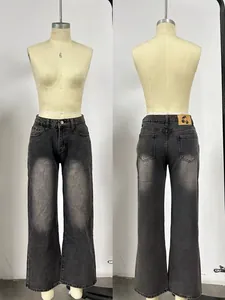 Detail of vintage washed gray denim jeans with cherry leather patch and five pockets