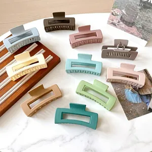 Matte rectangular hollow hair claws in various Morandi colors shown on a wooden tray