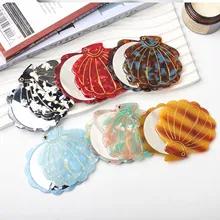 Collection of shell-shaped folding portable mirrors in various marble patterns