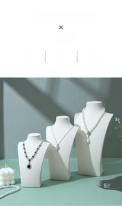 Three elegant necklaces on neck busts featuring pearls, rose and teardrop pendants