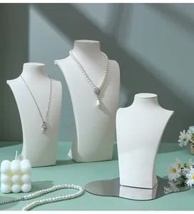 Three-piece white jewelry neck display stand set for necklaces in minimalist studio setting