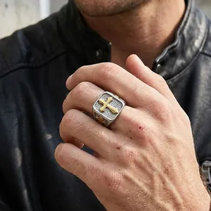 Detail of silver signet ring with golden cross on matte square surface for men