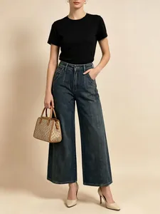 Dettaglio dei jeans a gamba larga a vita alta blu scuro con cuciture verticali