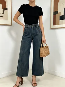 Dettaglio dei jeans a vita alta a gamba larga in indaco scuro con pieghe e fit ampio
