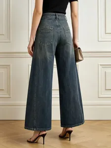 Dettaglio di jeans a gamba larga a vita alta con lavaggio grigio e tasche posteriori reali