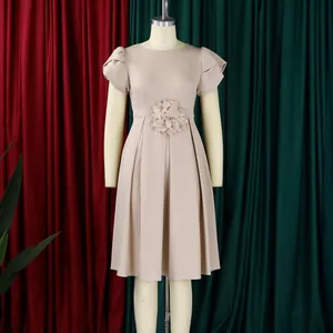 Detailaufnahme von elegantem beigen Kleid mit Taillenblume und weichen Falten