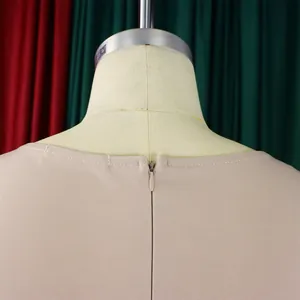 Detailaufnahme des verdeckten Reißverschlusses und beigen Webstoffs am eleganten Kleid