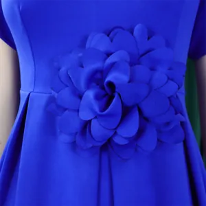 Detail eines eleganten hellblauen Kleides mit großer handgefertigter 3D-Blumenverzierung