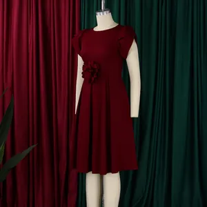 Detailansicht eines dunkelroten Kleides mit elegantem Blumenschmuck und Volantärmeln