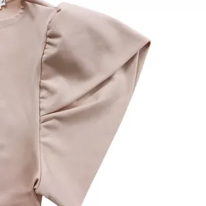 Detail der eleganten aprikosenfarbenen Puffärmel und des Rundhalsausschnitts am Sommerkleid
