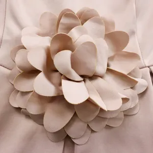 Detail der 3D-geschichteten Blüten-Dekoration auf dem eleganten altrosa afrikanischen Kleid