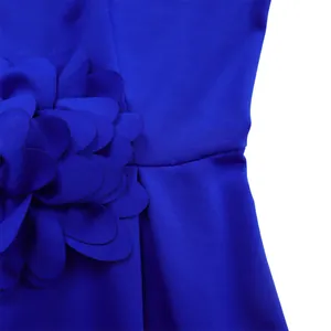 Detailansicht eines königsblauen Kleides mit einer großen 3D-Blumenapplikation aus Stoff