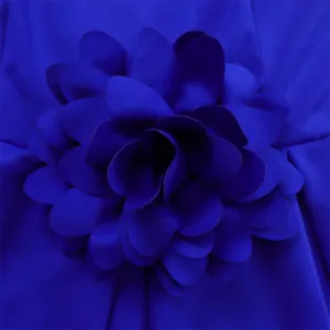 Detail von königsblauer 3D-Blumendekoration auf elegantem afrikanischem Kleid aus Texturstoff
