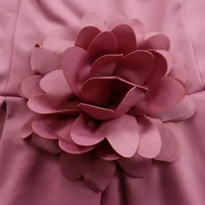 Detaillierte Nahaufnahme einer rosa 3D-Stoffblume als Dekor an einem Kleid