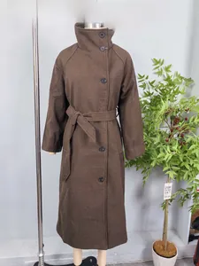 Detail of dark brown wool coat with high collar, black buttons and matching waist belt
