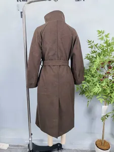Detail view of the back vent and belted waist on a long dark brown wool coat