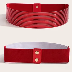 Detail van een rode elastische brede riem met gouden drukknopen en ribtextuur