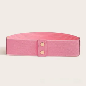 Detailweergave van roze elastische tailleband met gouden gespen en lederen afwerkingen