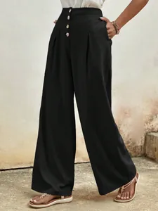 Detail of high waisted black wide leg pants with vintage buttons and pleated design