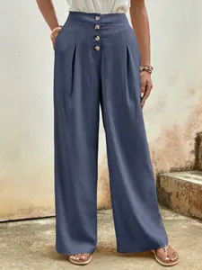 Detail of high waisted wide leg navy cotton trousers with vintage wooden buttons
