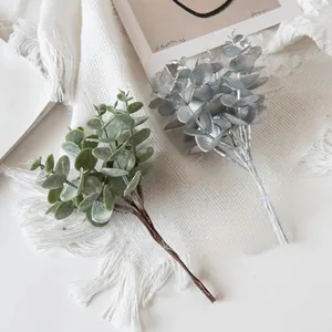 Close-up of green and silver faux eucalyptus leaves with natural frosted texture detail