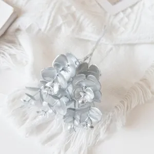 Macro detail of artificial silver eucalyptus leaves with metallic luster and texture