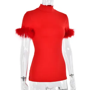Detail of red slim fit top featuring high neck design and feather trim on short sleeves