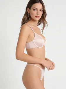 Détail de l'ensemble de lingerie en satin rose champagne avec dentelle et coutures festonnées