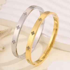 Detailed shot of polished titanium steel bangles with floral motifs on a white stand