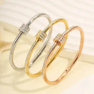 Macro shot of titanium steel bangles with sliding diamond accents in silver, gold, and rose gold