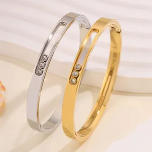 Detail of gold and silver stainless steel bangles with three sliding crystals in center