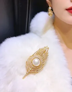 Macro detail of luxury feather brooch and pearl earrings set against white fur texture