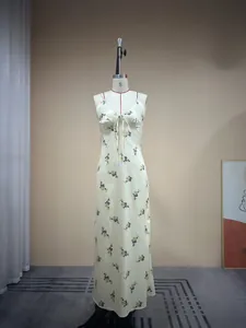 Détail du col en V en dentelle et du nœud sur une robe nuisette fleurie crème