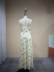 Détail de la fermeture éclair au dos et motif floral sur une robe longue crème