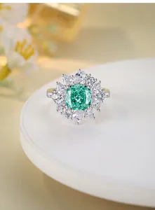 Macro shot of s925 silver ring featuring a green cushion-cut stone and diamond halo