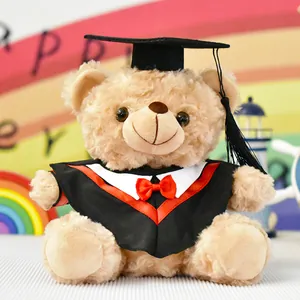 Primo piano di un orsetto di peluche con cappello e toga da laurea e un fiocco rosso