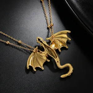 Macro shot of a golden dragon pendant with matte textured wings on a beaded chain