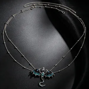 Close-up of a double-layered bead chain necklace featuring a blue enamel dragon pendant