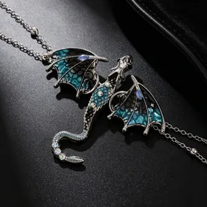 Macro detail of silver dragon necklace featuring blue enamel wings and inlaid crystals