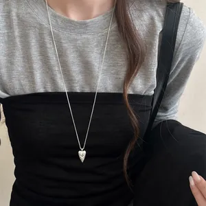 Detail view of Korean style pointed heart necklace with unique engraved tribal patterns