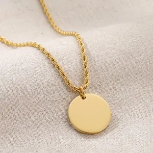 Vue détaillée d'un collier avec pendentif disque rond plaqué or 18K sur une chaîne corde élégante