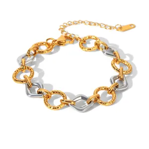 Macro view of two-tone stainless steel geometric chain bracelet with textured gold rings