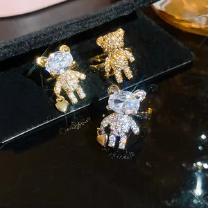 Detailed view of bear-shaped ear clips with sparkling rhinestones on black velvet display