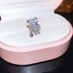 Detailed macro shot of a sparkling cubic zirconia teddy bear ear cuff in a pink jewelry box