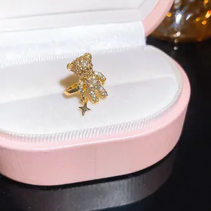 Detailed close-up of a gold teddy bear ear cuff featuring sparkling stones and a star charm