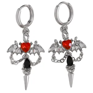 Detailed shot of gothic bat wing earrings with red heart gems and black teardrop pendants