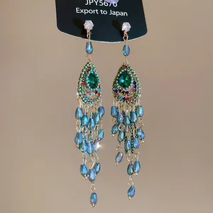 Detail showing ethnic style beaded tassel earrings with green and blue crystal drops
